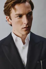 Blazer de corte regular fit confeccionado en lana italiana, con diseño de raya diplomática. Presenta cuello con solapas de pico, cierre frontal de botonadura cruzada, bolsillos de vivo en el pecho y bolsillos de solapa en la cadera.