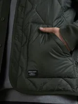 Campera acolchada verde militar con cuello mao, cierre frontal con botones a presión y bolsillos laterales.