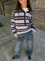 Sweater tipo chomba de tejido de punto con diseño a rayas horizontales en tonos celeste y marrón. Presenta cuello polo, cierre frontal con botones y mangas largas con corte holgado.