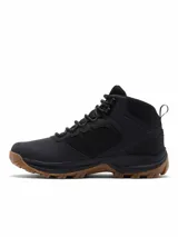 Bota de trekking Columbia modelo Transverse Hike, de color negro con suela de caucho marrón, confeccionada en malla y piel con tecnología impermeable y transpirable.