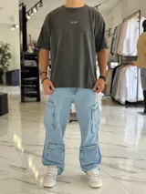 Remera oversize de color gris con efecto gastado (acid wash). Presenta un diseño de tipografía en la parte frontal y un gran estampado en la espalda con la inscripción "Create Bigger". Cuenta con mangas cortas y un calce holgado y cómodo.