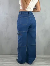 Pantalón jean azul de tiro alto, corte wide leg y estilo cargo, con bolsillos laterales con cierre.