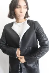 Campera de napalán de cuero genuino en color negro, con interior de piel sintética blanca y diseño de corte recto sin cuello.
