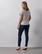 Remera color beige de tejido melange con escote en V y aplique de crochet en el frente.