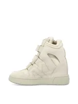 Zapatilla de caña alta, color blanco hueso, con cierre de tres tiras de velcro. Presenta recortes en gamuza y paneles acolchados en el lateral, con suela de goma gruesa.