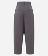 Pantalón de sastrería modelo barrel, de tiro alto y corte amplio con piernas anchas. Presenta pliegues frontales, trabillas para cinturón y recortes decorativos en la parte delantera.