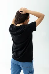 Remerón negro de corte oversize con estampa de corazón derretido sobre fondo de rayas rosas y rojas.