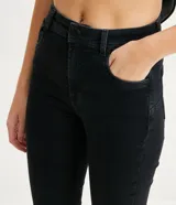 Pantalón skinny de jean negro, de cintura alta, con bolsillos y trabillas para cinturón.
