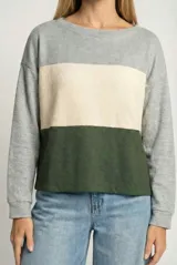 Sweater de punto con diseño tricolor en bloques horizontales de colores gris, beige y verde. Presenta cuello redondo, mangas largas y un corte holgado tipo oversize.