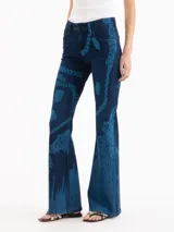Jeans oxford de tiro medio-bajo, confeccionados en mezcla de algodón y elastano. Presentan un diseño ajustado hasta la rodilla y terminación acampanada, con un patrón gráfico de grabado láser cyanotype en tonos azules sobre base oscura.
