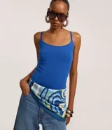 Body femenino de microfibra color azul eléctrico, con escote redondo al frente y breteles finos. Presenta un recorte en la espalda que deja la misma descubierta.