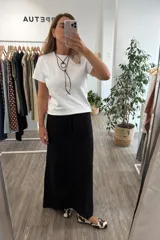 Falda larga tejida en color negro, con diseño de punto abierto y cintura ajustable mediante cordón.