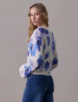 Cárdigan tejido calado color beige con estampado floral en tonos de azul y lila. Escote en V y cierre frontal con lazo.