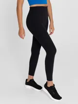Calza deportiva de tiro alto con tecnología seamless y largo ankle. Presenta un diseño liso en color negro con logo pequeño en la cadera.