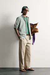 Camisa relaxed fit confeccionada en tejido de algodón, con diseño de rayas verticales en tonos azul y blanco, cuello con botones y manga larga.