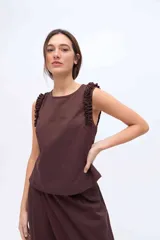Musculosa de Margo color marrón, de corte recto con escote redondo y tirantes anchos adornados con volados fruncidos. Confeccionada en mezcla de algodón y Tencel.