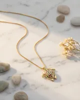 Cadena de eslabones finos con dije en forma de tortuga, con acabado dorado y detalles de circonias multicolor incrustadas en el caparazón.