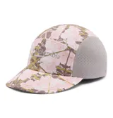 Gorro tipo gorra Columbia modelo Wingmark Cap, con paneles laterales de malla gris y diseño estampado camuflado en tonos rosados y blancos en el frente y la visera. Cuenta con logo bordado de la marca.