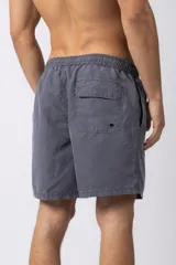 Short de baño de corte relajado en color gris azulado con efecto lavado. Cuenta con cintura elastizada con cordón ajustable, bolsillos laterales y una pequeña etiqueta decorativa en el ruedo.