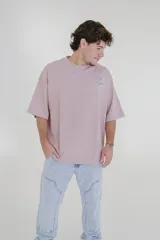 Remera color beige de corte holgado con estampado pequeño en el pecho.