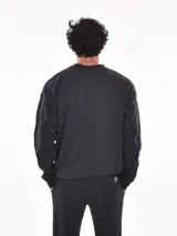 Buzo de algodón color verde grisáceo, de corte regular y cuello redondo. Presenta costuras decorativas en las mangas y puños y cintura acanalados.