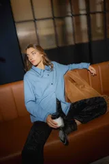 Camisa de jean azul con rayas verticales blancas, cuello con volados y bordado de onditas rojas.