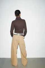 Chaqueta de felpa negra con cuello solapa, manga larga con puño, bolsillos de plastrón en el delantero y cierre frontal con cremallera.