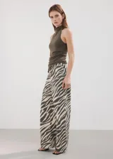 Jeans de corte wide leg con estampado animal print tipo cebra en tonos beige y negro, tiro medio y diseño de cinco bolsillos.