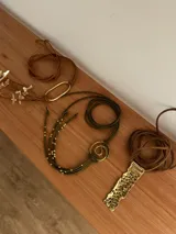 Collar artesanal con dije de espiral de bronce y cordón de gamuza verde con cuentas de bronce.