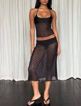 Conjunto de dos piezas color negro confeccionado en tul plumeti transparente con lunares. Incluye un top de escote recto con breteles finos y una falda midi de tiro bajo.