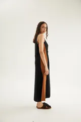 Vestido largo de punto de algodón y acrílico, sin mangas, con escote redondo y tiranchos. Diseño en bloques de color negro y marrón tostado, con corte diagonal en la cintura y costadillos en contraste.
