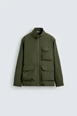 Parka de hombre color verde militar, corte regular, confeccionada en tejido técnico ligero. Presenta cuello subido, manga larga con puño ajustable y cuatro bolsillos frontales de plastrón con solapa. Cierre frontal con cremallera.