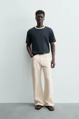 Camiseta de manga corta y cuello redondo, color azul marino, con ribete de contraste en color crema alrededor del cuello.