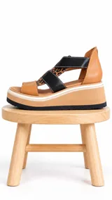 Sandalias de cuero con plataforma alta y suela dentada negra, diseño de tiras cruzadas en color camel, negro y detalle animal print leopardo.