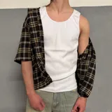 Musculosa blanca de algodón con cuello redondo y sisas ribeteadas.