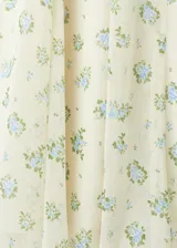 Falda midi evasé de color blanco con estampado floreado en tonos azules y verdes. Cuenta con cierre lateral y forro interior.