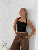 Top negro con cuello halter y espalda descubierta, confeccionado en microfibra.