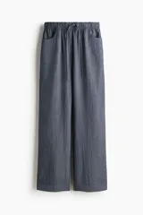 Pantalón recto de corte holgado con cintura elástica de tiro alto y cordón ajustable. Presenta bolsillos delanteros y traseros abiertos.