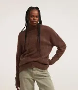 Suéter de punto color crema con cuello redondo y mangas largas ajustadas. Modelo slim alargado con efecto de pelitos.