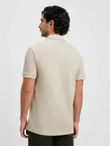 Polo marrón de manga corta confeccionada en tejido de piqué de algodón.