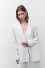 Blazer de lino color blanco, de corte oversize, con solapas de muesca y cierre con dos botones.