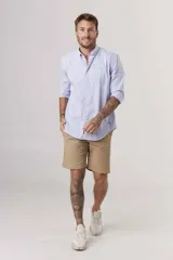 Camisa de hombre color crema, de corte clásico, con cuello abotonado y mangas largas.