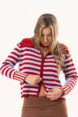 Saco tejido de punto a rayas horizontales en color celeste y rojo, con cuello alto, cierre frontal doble deslizador y puños con diseño en contraste. Presenta un pequeño bordado en el pecho.