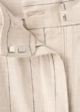 Pantalón recto color beige de tiro medio, con estampado de raya diplomática, trabillas para cinto y cierre frontal con gancho y cremallera.
