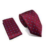 Set compuesto por una corbata y un pañuelo de bolsillo a juego, ambos de color bordó con estampado de pequeñas figuras en azul.