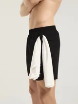 Short deportivo tipo runner color negro, confeccionado en tejido técnico de secado rápido. Presenta un corte corto, cintura elástica y logo reflectante en la pierna derecha.