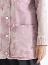 Chaqueta de silueta amplia y relajada con efecto lavado en tono rosado. Presenta cuello de corderoy en contraste, cierre frontal con botones y bolsillos frontales.