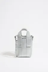 Bolso bandolera mini de piel color plateado, con doble asa de mano y asa bandolera ajustable. Cierre con tira de snap y logo estampado.