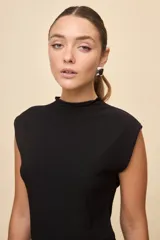 Top de calce entallado, sin mangas y con cuello alto, confeccionado en tejido texturado de líneas simples.