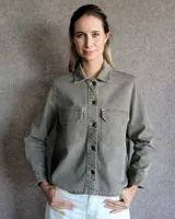 Sobrecamisa color verde militar, de corte recto, con cuello camisero, cierre frontal con botones a tono, mangas largas con puños abotonados, dos bolsillos de parche con solapa abotonada en el pecho y bajo recto.
